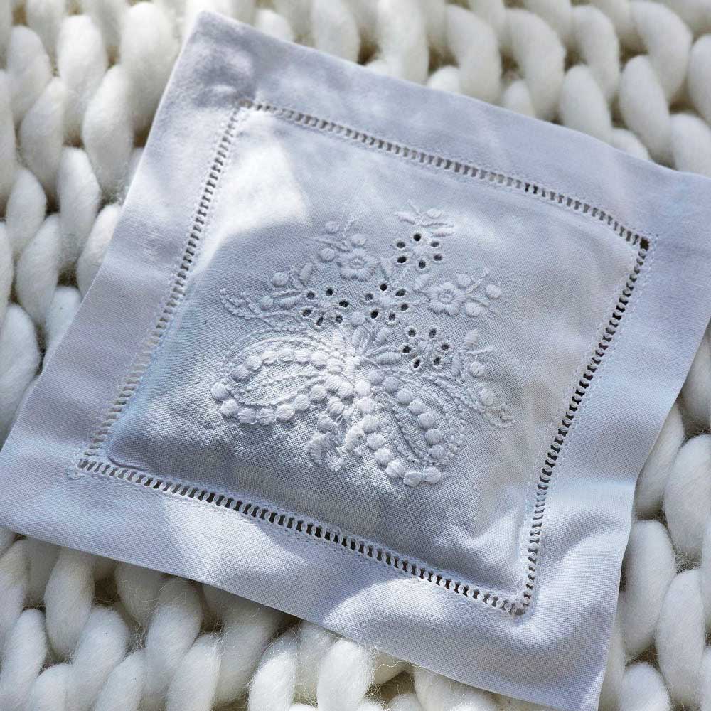 Keep laundry and linens smelling fresh with our Embroidered Lavender Sachet. This crisp white cotton sachet case is embroidered in Portugal with a French floral design and has hemstitched detail around the edges. The inner sachet pillow is filled with lavender from Provence, France . The lavender scent will last for years with just a squeeze or two from time to time. It features a pocket in the back so the lavender bag can be easily removed/replaced and the case can be washed if needed.