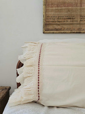 Our Eyelet Ruffles with Velvet Ribbon Pillowcase, Set of Two lends dreamy cottage style to any bedroom. These cream pillowcases feature a double layer of ruffle edges with exquisite floral eyelet detail with a dark rose velvet ribbon woven through a crochet border. The cream color is warm, falling on the yellow spectrum. This lace edge pillowcase will add texture and a charming vintage look to your room.