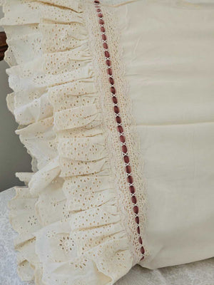 Our Eyelet Ruffles with Velvet Ribbon Pillowcase, Set of Two lends dreamy cottage style to any bedroom. These cream pillowcases feature a double layer of ruffle edges with exquisite floral eyelet detail with a dark rose velvet ribbon woven through a crochet border. The cream color is warm, falling on the yellow spectrum. This lace edge pillowcase will add texture and a charming vintage look to your room.