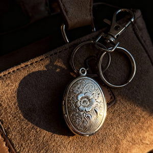 Capture a touch of vintage elegance with this floral oval photo locket bag charm. Whether used as a keychain or bag accessory, it effortlessly combines nostalgic floral design with a personal keepsake, making your everyday style uniquely yours.