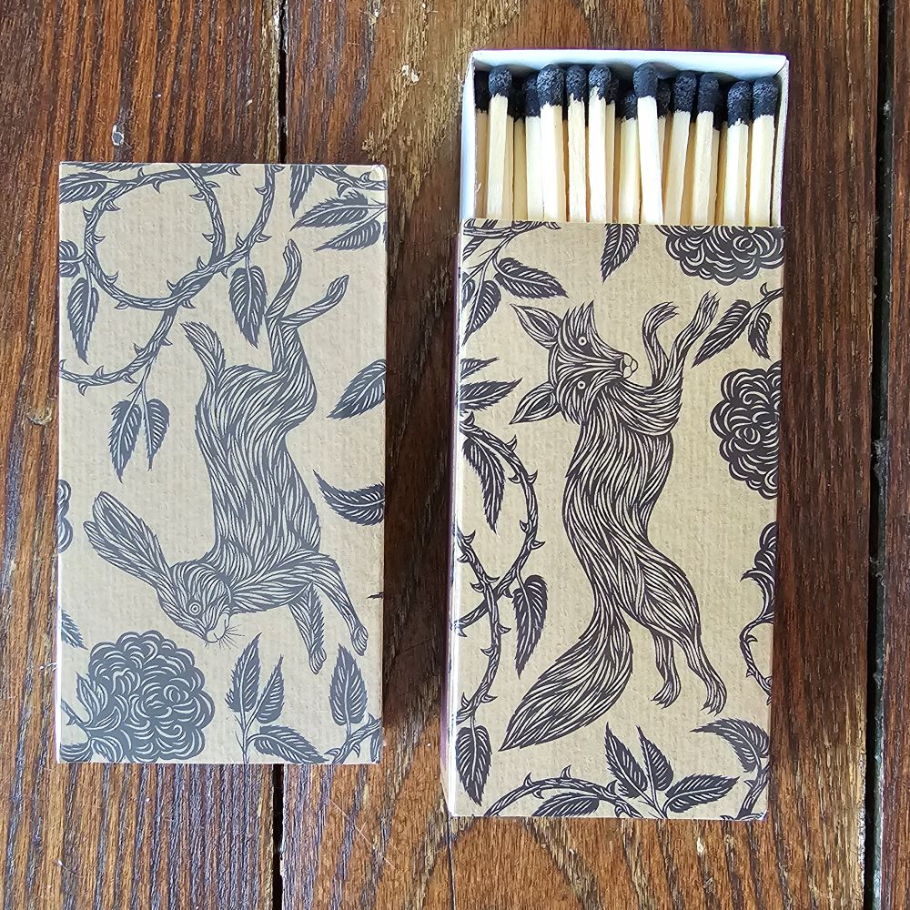 These stylish wood matches, with a fox and hare design, are the perfect complement to any space. Modern, chic, with a vintage graphic design, they are perfect for any room. The match striker is side of the box for easy lighting. Safety matches, 50 sticks per cardboard box. Includes set of two boxes.