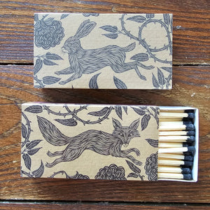 These stylish wood matches, with a fox and hare design, are the perfect complement to any space. Modern, chic, with a vintage graphic design, they are perfect for any room. The match striker is side of the box for easy lighting. Safety matches, 50 sticks per cardboard box. Includes set of two boxes.