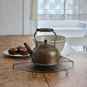 The Wire French Cooling Rack offers an elegant way to protect your table or surface. Its vintage French country feel makes a charming addition to any farmhouse or cottage style kitchen and baking station. The open wire weave makes it an ideal cooling rack for kettles and small baking dishes or for breads other baked goodies. The wire cooling rack is 12” Diam and 1”H