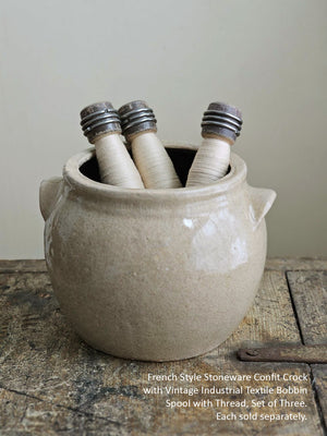 French Style Stoneware Confit Crock with Vintage Industrial Textile Bobbin Spool with Thread, Set of Three, on a wooden surface.