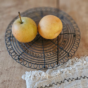 This hand-crafted French Wire Trivet offers an elegant way to protect your table or surface. Its vintage French country design makes a charming addition to any farmhouse or cottage style kitchen. The open wire weave makes it an ideal cooling rack for kettles and small baking dishes or for breads other baked goodies. The trivet is 6.25” Diam at the base and 7.5” in diam with outer wire designed edge and 0.75”H