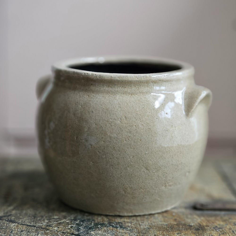 This antique reproduction French Style Stoneware Confit Crock is inspired by salt glazed pottery from early 20th century, found in farmhouses throughout the US and Europe. This sturdy, rustic crock has an aged beige patina, making this piece a perfect accent for those who love the perfectly imperfect look of vintage style home decor. 