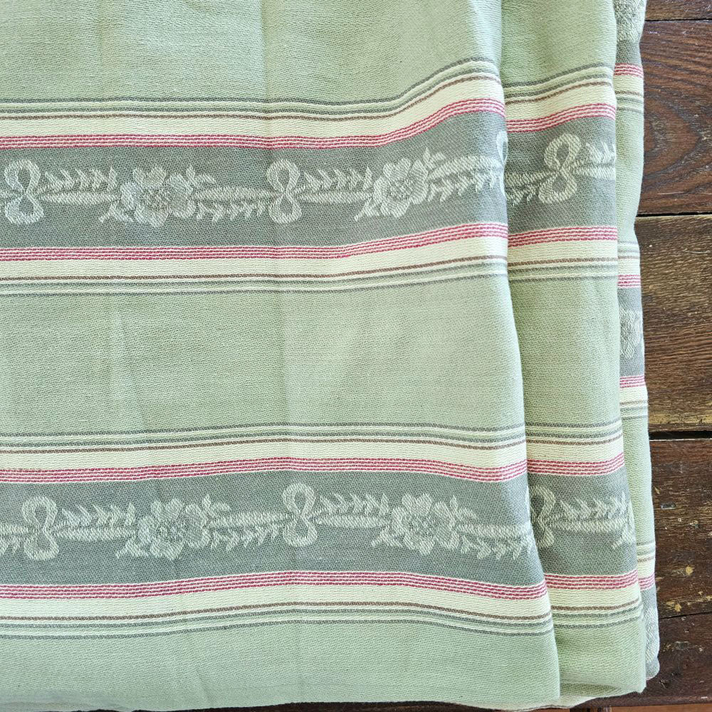 Our French Fabric by the Yard features a vintage style Green Woven Jacquard. The intricate woven detail features darker green bands with woven flower and bow pattern accented with red stripes. Bring the elegance of French Country style to any project.

This is a high quality cotton fabric that can be used for upholstery, curtains, pillows, and more.

Made In France.