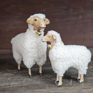 These folksy sheep figures, with fluffy cotton bellies and wooden style legs, brings charm to any room. Inspired by vintage German Putz, which is derived from putzen, meaning to decorate, these figures have an old-world quality. Features an ivory satin ribbon with a bell around the neck. These lovable white sheep figures, available in two sizes, are ready to graze on your bookshelf or tabletop and add a bit of charm to any room. Made of Polyresin, Stone Powder. Select size in menu below. Includes one sheep