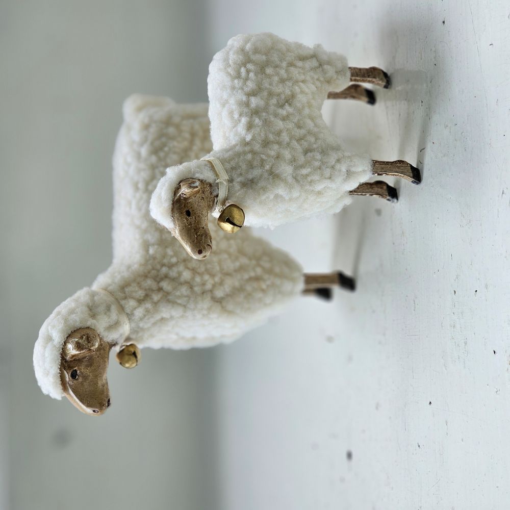 These folksy sheep figures, with fluffy cotton bellies and wooden style legs, brings charm to any room. Inspired by vintage German Putz, which is derived from putzen, meaning to decorate, these figures have an old-world quality. Features an ivory satin ribbon with a bell around the neck. These lovable white sheep figures, available in two sizes, are ready to graze on your bookshelf or tabletop and add a bit of charm to any room. Made of Polyresin, Stone Powder. Select size in menu below. Includes one sheep