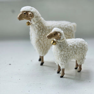 These folksy sheep figures, with fluffy cotton bellies and wooden style legs, brings charm to any room. Inspired by vintage German Putz, which is derived from putzen, meaning to decorate, these figures have an old-world quality. Features an ivory satin ribbon with a bell around the neck. These lovable white sheep figures, available in two sizes, are ready to graze on your bookshelf or tabletop and add a bit of charm to any room. Made of Polyresin, Stone Powder. Select size in menu below. Includes one sheep