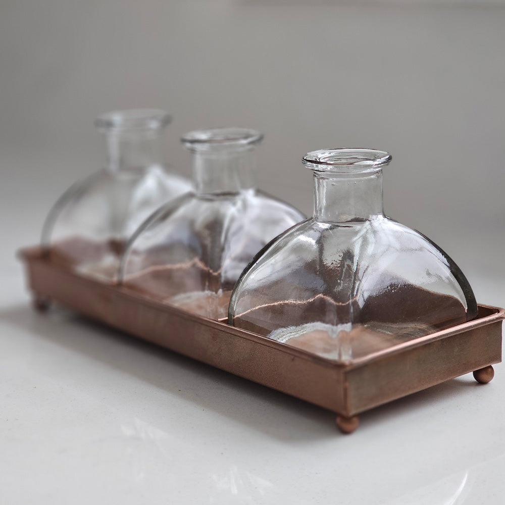You’re going to fall in love with this old pharmacy inspired set!  Includes three glass bottles along with a copper style tray. These sweet bottles make perfect bud vases, allowing small flowers and herbs to be displayed with ease, which makes this set perfect for creating charming centerpiece designs.