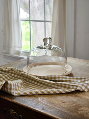 Elegant entertaining is made easy with our Glass Cloche with Wood Tray. Create a timeless presentation with this bell jar style cloche and natural wood plate. In addition to serving guests in style, this cloche and tray combo makes a great way to display small object and keepsakes, such as bird nests and more. The wood plate is natural--with no finish and measures 8.5" dia. The Glass cloche measures 6.75" diam x 5.50"H