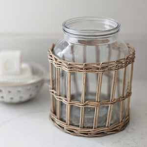This Glass Jar with Willow Basket Sleeve brings French Country cottage charm to your home or garden decor. The thick, clear glass jar insert allows you to enjoy it as an elegant candle hurricane or use it as vase packed with your favorite flowers. You can use the pieces separately. The Glass jar is beautiful for storage or display while the willow basket makes an attractive sleeve for garden pots. 7” diam x 9”H