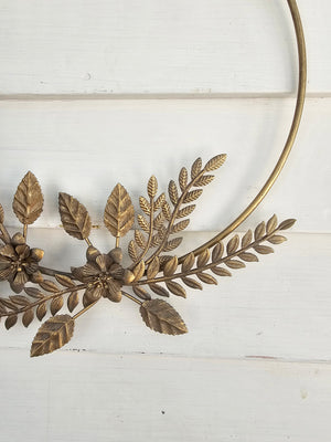The Gold Metal Flower Wreath is an everlasting statement piece that looks gorgeous on a door frame, above the fireplace, or even as a table centerpiece. Crafted of iron with pressed metal flowers and foliage. May patina or rust if left outdoors. 12"L x 14.5"H