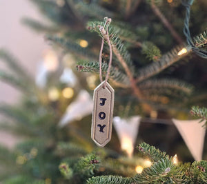 Enhance your holiday decor with our Gold Joy Tag Ornament Set. Each ornament features a durable leather loop for easy hanging and can be used to add a special touch to your gifts or adorn your tree. Celebrate the season with this elegant and versatile tag. Set of three.