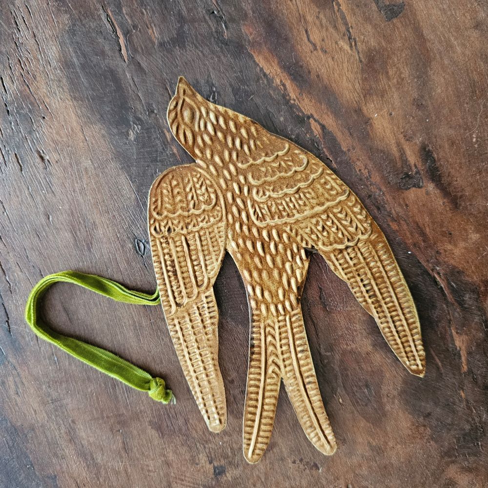 Add a magical touch to any room with our Golden Spirit Bird Ornament with Velvet Ribbon. The small gilded tin bird appears to float in the air as they hang from its velvet ribbon. Makes a beautiful gift topper or Christmas tree ornament. Approximately 6.5"L x 4"H