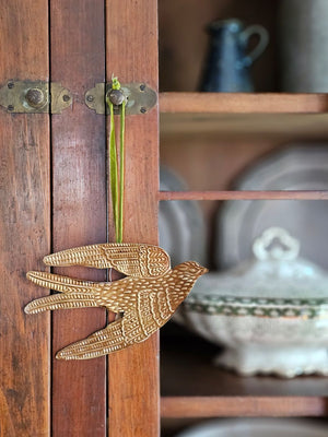 Add a magical touch to any room with our Golden Spirit Bird Ornament with Velvet Ribbon. The small gilded tin bird appears to float in the air as they hang from its velvet ribbon. Makes a beautiful gift topper or Christmas tree ornament. Approximately 6.5"L x 4"H