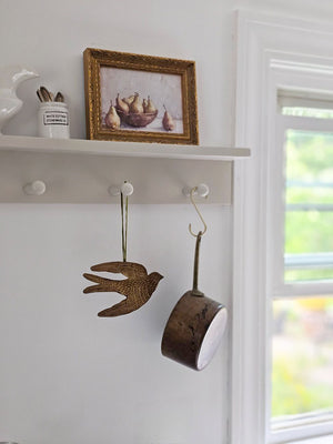 Add a magical touch to any room with our Golden Spirit Bird Ornament with Velvet Ribbon. The small gilded tin bird appears to float in the air as they hang from its velvet ribbon. Makes a beautiful gift topper or Christmas tree ornament. Approximately 6.5"L x 4"H