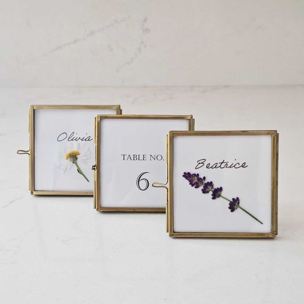 Elevate your event with our Gold and Glass Easel Picture Frame Place Card Holder Set. Featuring a refined vintage-inspired design accented in gold, these floating picture frames offer a unique way to create place card settings or table numbers that will delight guests and spark conversation. &nbsp;Perfect for weddings, parties, or any gathering, their elegant gold finish and clear glass let your creativity shine—endless possibilities await to make your event memorable! includes three empty 3 x 3 frames 