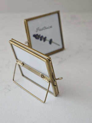 Elevate your event with our Gold and Glass Easel Picture Frame Place Card Holder Set. Featuring a refined vintage-inspired design accented in gold, these floating picture frames offer a unique way to create place card settings or table numbers that will delight guests and spark conversation. &nbsp;Perfect for weddings, parties, or any gathering, their elegant gold finish and clear glass let your creativity shine—endless possibilities await to make your event memorable! includes three empty 3 x 3 frames 