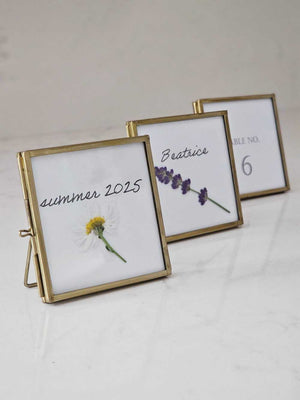 Elevate your event with our Gold and Glass Easel Picture Frame Place Card Holder Set. Featuring a refined vintage-inspired design accented in gold, these floating picture frames offer a unique way to create place card settings or table numbers that will delight guests and spark conversation. &nbsp;Perfect for weddings, parties, or any gathering, their elegant gold finish and clear glass let your creativity shine—endless possibilities await to make your event memorable! includes three empty 3 x 3 frames 