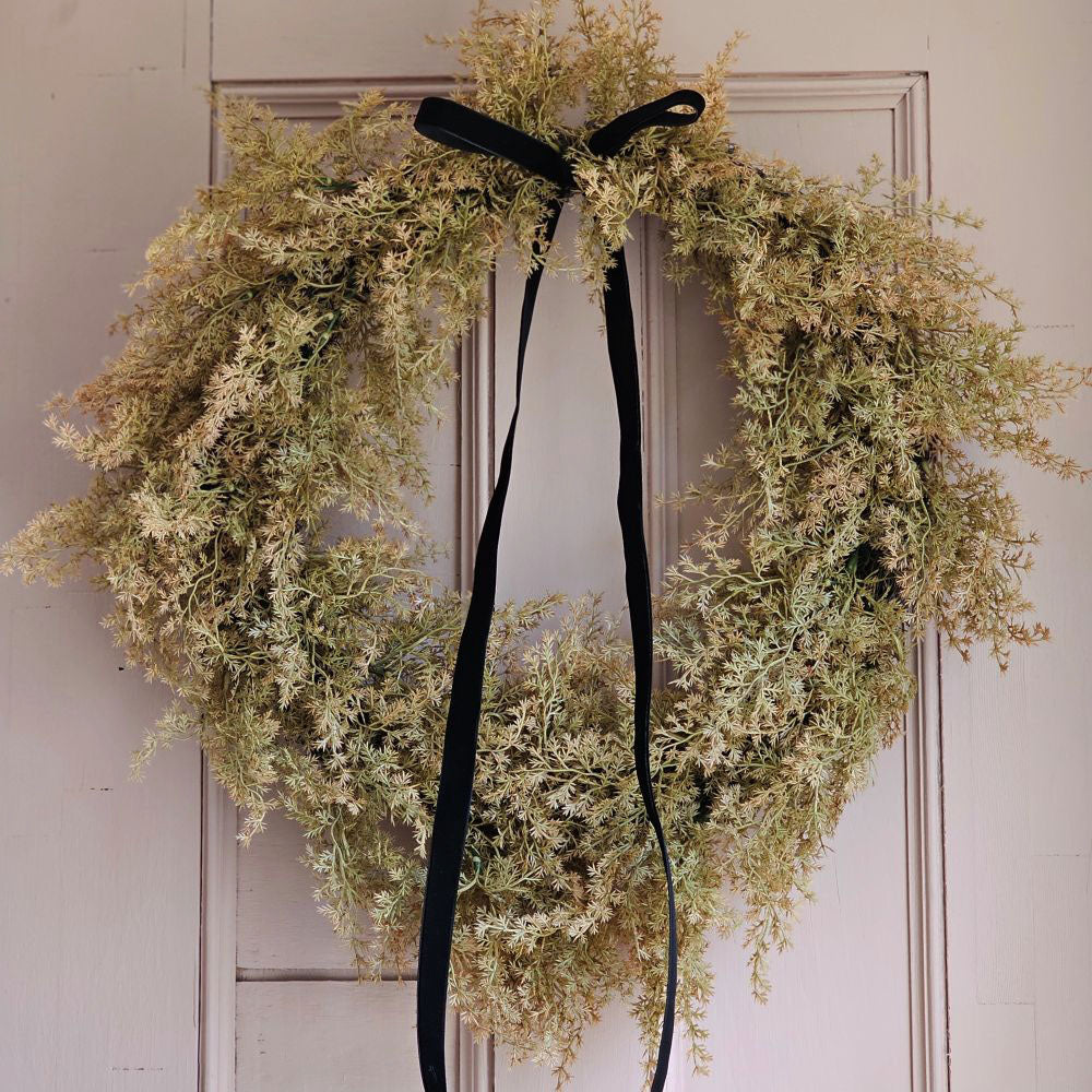 Enhance your seasonal decor with the sophisticated charm of our Golden Cypress Wreath adorned with a Black Velvet Ribbon. Crafted from faux cypress, this wreath offers a distinctive and refined look that brings a subtle, moody elegance to any doorway or interior space.19" Diam