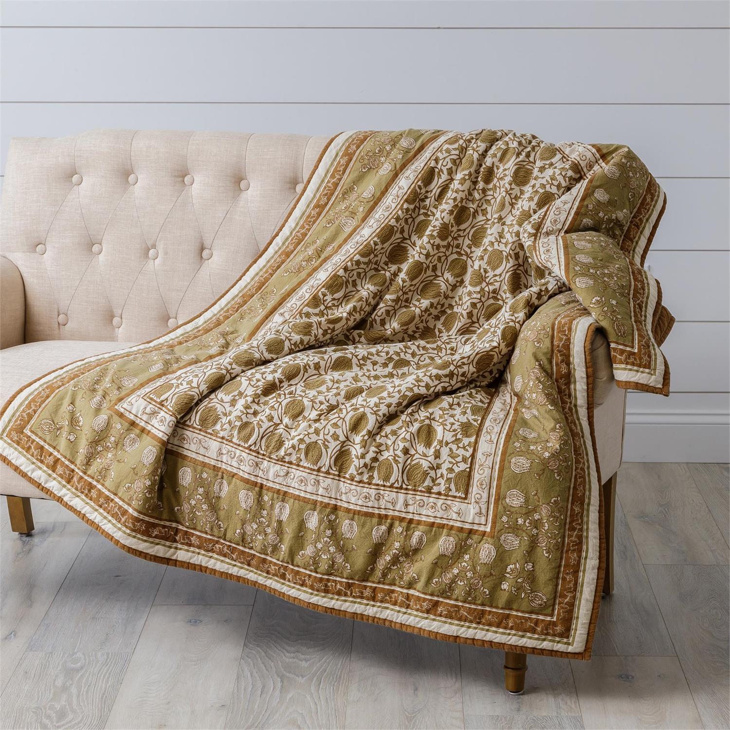 Enhance your guest room or reading corner with the elegant Golden Olive and Brown Block Print Quilted Throw. Showcasing a refined golden olive floral pattern accented in brown, it features a solid brown reverse side. Made from 100% cotton, this quilted throw offers both comfort and easy maintenance with machine wash-ability. Measuring 50”W x 60”H, it adds a touch of warmth and sophistication to any space.