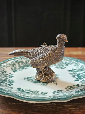The Golden Pheasant Ornament features an artfully distressed gold finish and intricate feather detailing that evokes vintage charm and sophistication. Add timeless elegance to your tree or use as a gift topper. Made of resin and generously sized, it makes stunning nature-inspired display.