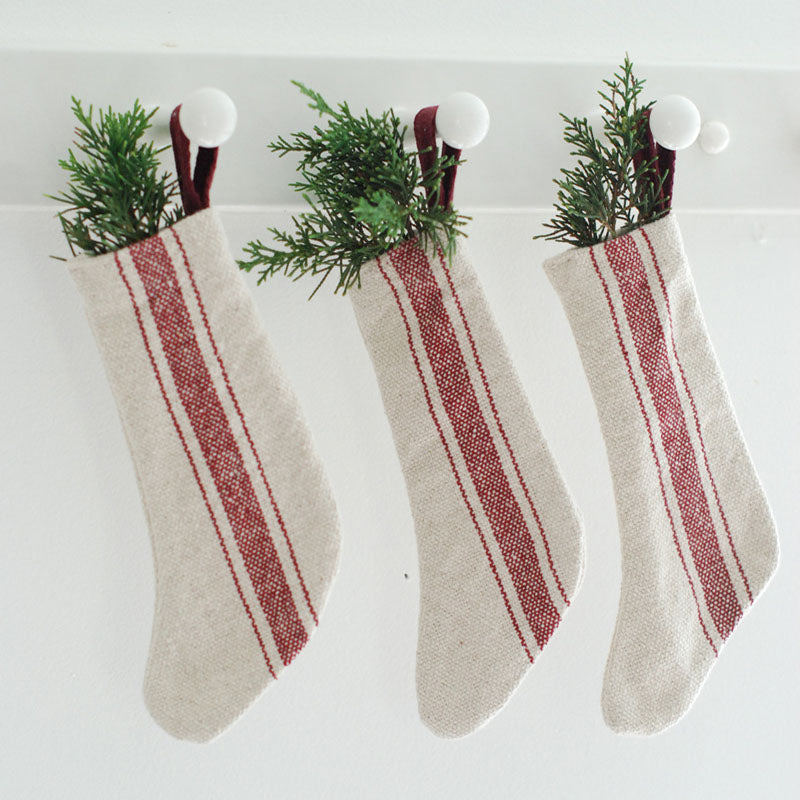 Our Red Stripe Grain Sack Stockings, Set of Three looks so charming whether you're Christmas style is French Country, Vintage Farmhouse, or classic Nordic style. This set of three mini stockings offers an old-fashioned look, inspired by French grain sacks. 100% Cotton. Set of Three.