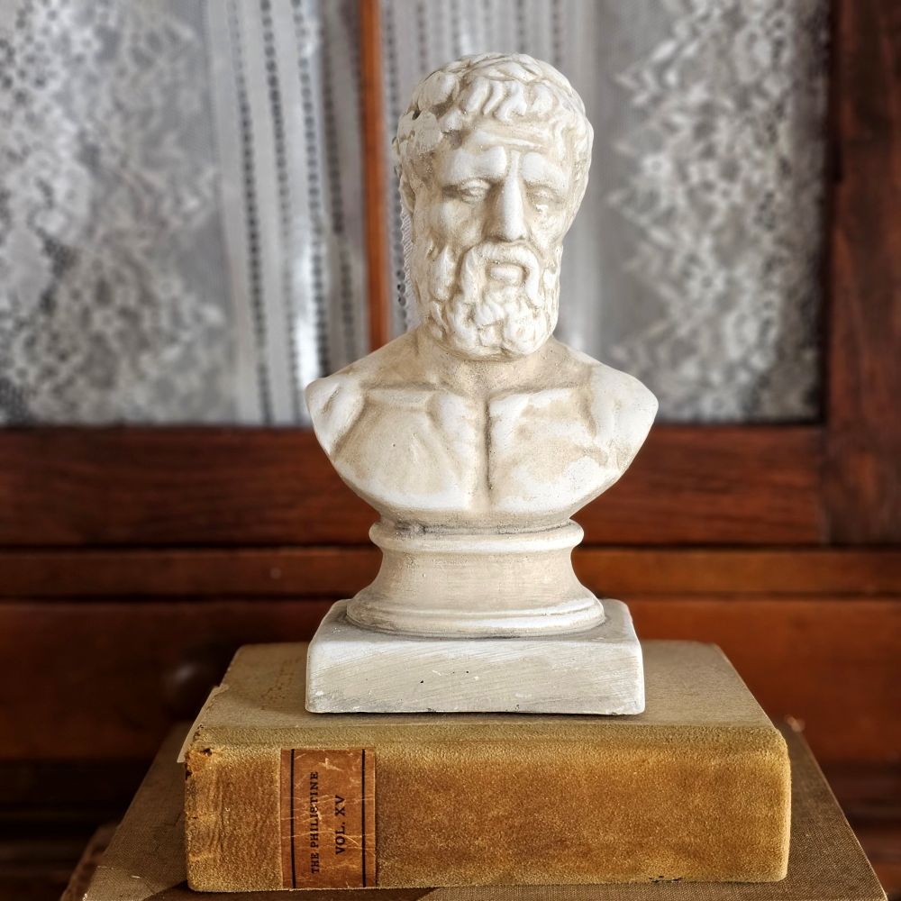 Elevate your interior with this distinguished plaster bust, capturing the classical elegance of Hellenic style sculpture. An ideal accent for discerning collectors, this refined piece commands attention on mantels, shelves, and display surfaces, infusing your space with the enduring sophistication of ancient artistic tradition.