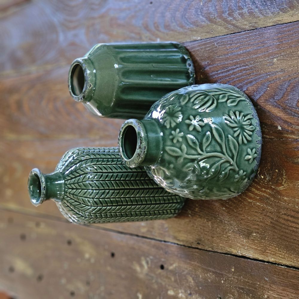 The Forest Green Vase Set brings a refined touch of nature into your living space, combining texture and elegance effortlessly. This curated trio features three distinct ceramic vases, each showcasing unique shapes and intricate textured patterns that create visual interest and depth. 