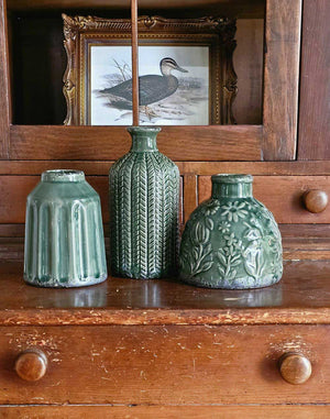 The Forest Green Vase Set brings a refined touch of nature into your living space, combining texture and elegance effortlessly. This curated trio features three distinct ceramic vases, each showcasing unique shapes and intricate textured patterns that create visual interest and depth. 