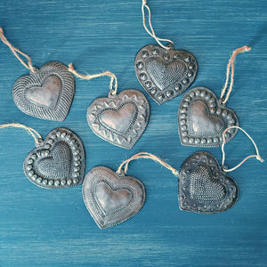 Each of these handmade Hammered Tin Heart Ornaments is a tiny work of art. These sweet milagro ornaments are heartfelt charms that symbolize love, hope, healing, and gratitude.
Sold as a set of seven, each heart is hand-cut, embossed, and painted with care. No two are alike — every set is a vibrant mix of colors and designs, perfect for spreading joy and inspiration. They make wonderful gift-toppers, ornaments, wall decor accents, or thoughtful tokens tucked into greeting cards or gift bags. 