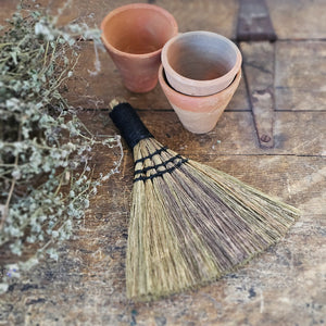 Whether you're cleaning up bread crumbs or keeping the potting shed tidy, this Handmade Hand Broom is a must-have around the farmhouse. These hand-made brooms crafted by Indonesian artisans in small batches and are perfect for displaying on a hook for an old-fashioned look.  Every product is made from natural material. Variations in pattern, color and appearance can be expected. 7.75"H