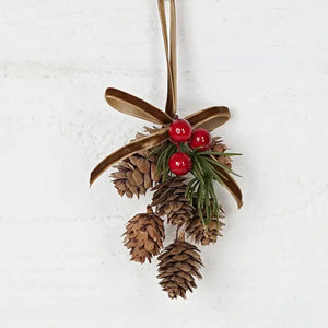 Add a touch of old-fashioned charm to your holiday decor with the Hanging Birchcones and Berries Ornament. Real birchcones beautifully contrast with faux red berries and a pine sprig adorned with a luxurious gold velvet bow. It's the perfect gift topper for a sophisticated and elegant touch. 2.5"W x 3"L