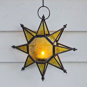 Let it glow! This charming Hanging Embossed Glass Star Candle Holder brings old-world ambiance to any room. This glass star light features embossed detail panes of yellow glass between an antiqued copper style metal framework. It holds one tealight candle (not included) and hangs from a chain. 