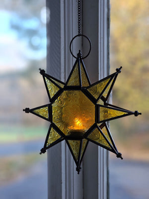 Let it glow! This charming Hanging Embossed Glass Star Candle Holder brings old-world ambiance to any room. This glass star light features embossed detail panes of yellow glass between an antiqued copper style metal framework. It holds one tealight candle (not included) and hangs from a chain. 