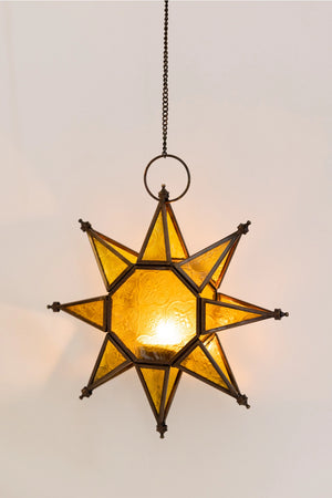 Let it glow! This charming Hanging Embossed Glass Star Candle Holder brings old-world ambiance to any room. This glass star light features embossed detail panes of yellow glass between an antiqued copper style metal framework. It holds one tealight candle (not included) and hangs from a chain. 