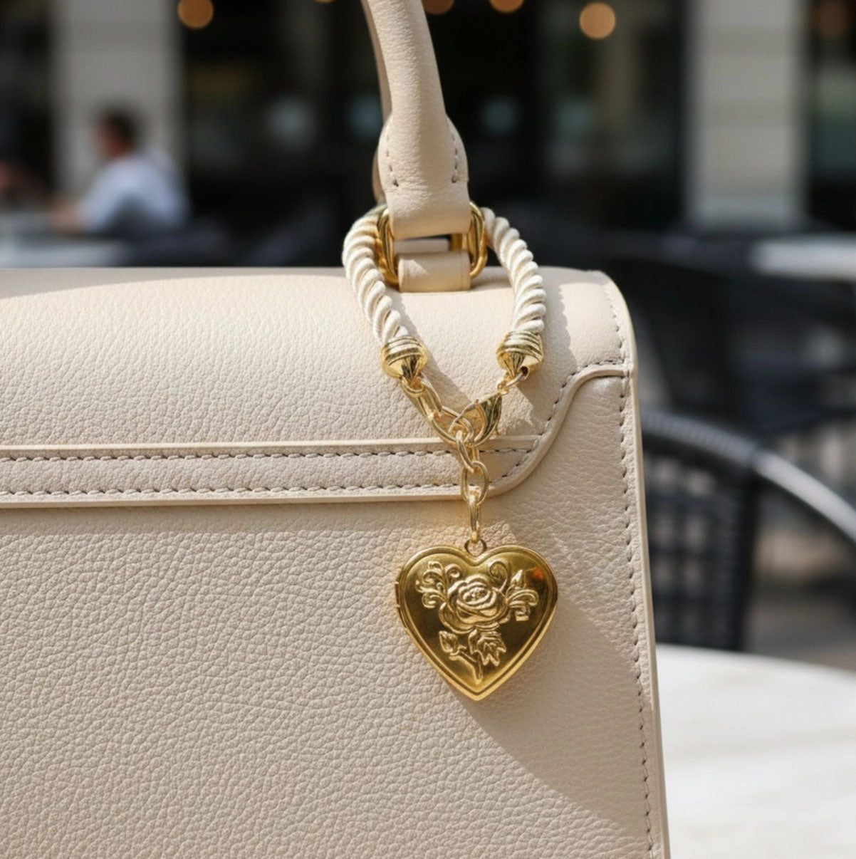 Keep cherished memories within reach using this elegant Heart Locket Bag Charm. A refined accessory that transforms any purse or tote with understated glamour, allowing you to carry what matters most wherever you go.

Featuring a creamy-beige cord design with a gold floral embossed heart locket. Dimensions: Total length: approx. 5 inch Locket size: 1x1 inch gold stainless steel that wont tarnish or fade

Made in the USA