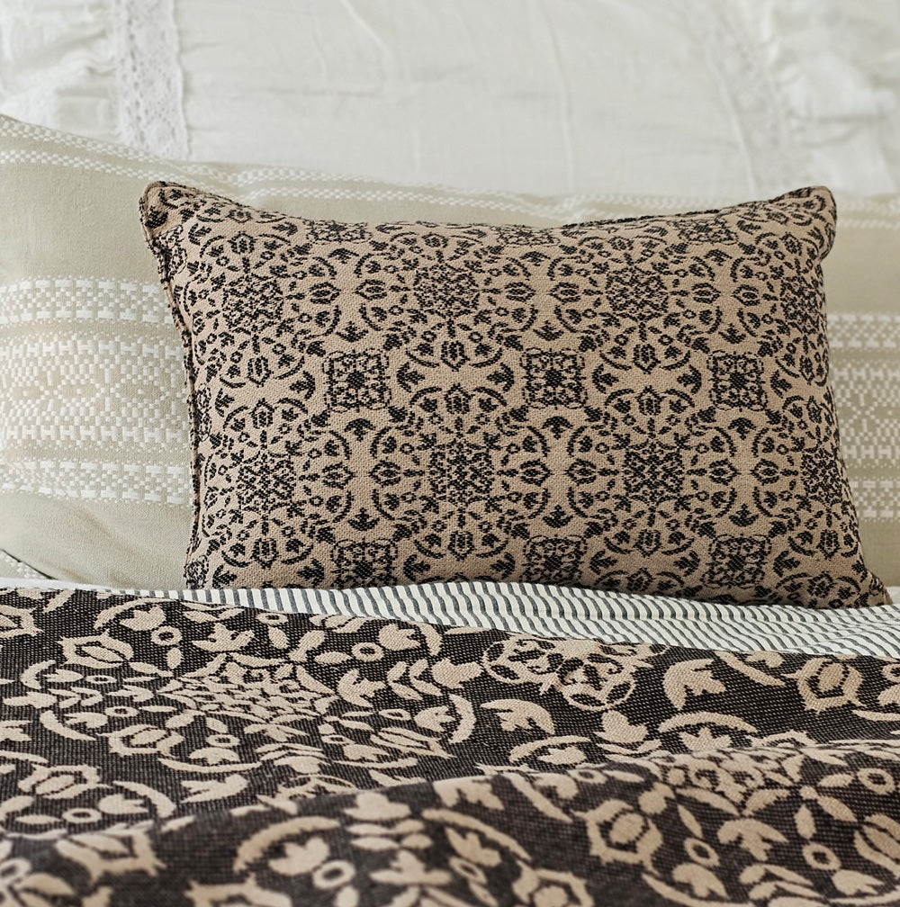 The Heritage Black and Tan Pillow is a small accent pillow that is perfect for creating a layered cottage look when used with other fabrics and style. It brings a timeless ambiance to any room. Adorned with a textured medallion design, this decorative throw pillow effortlessly adds warmth and character to your space with its old-world cottage charm.