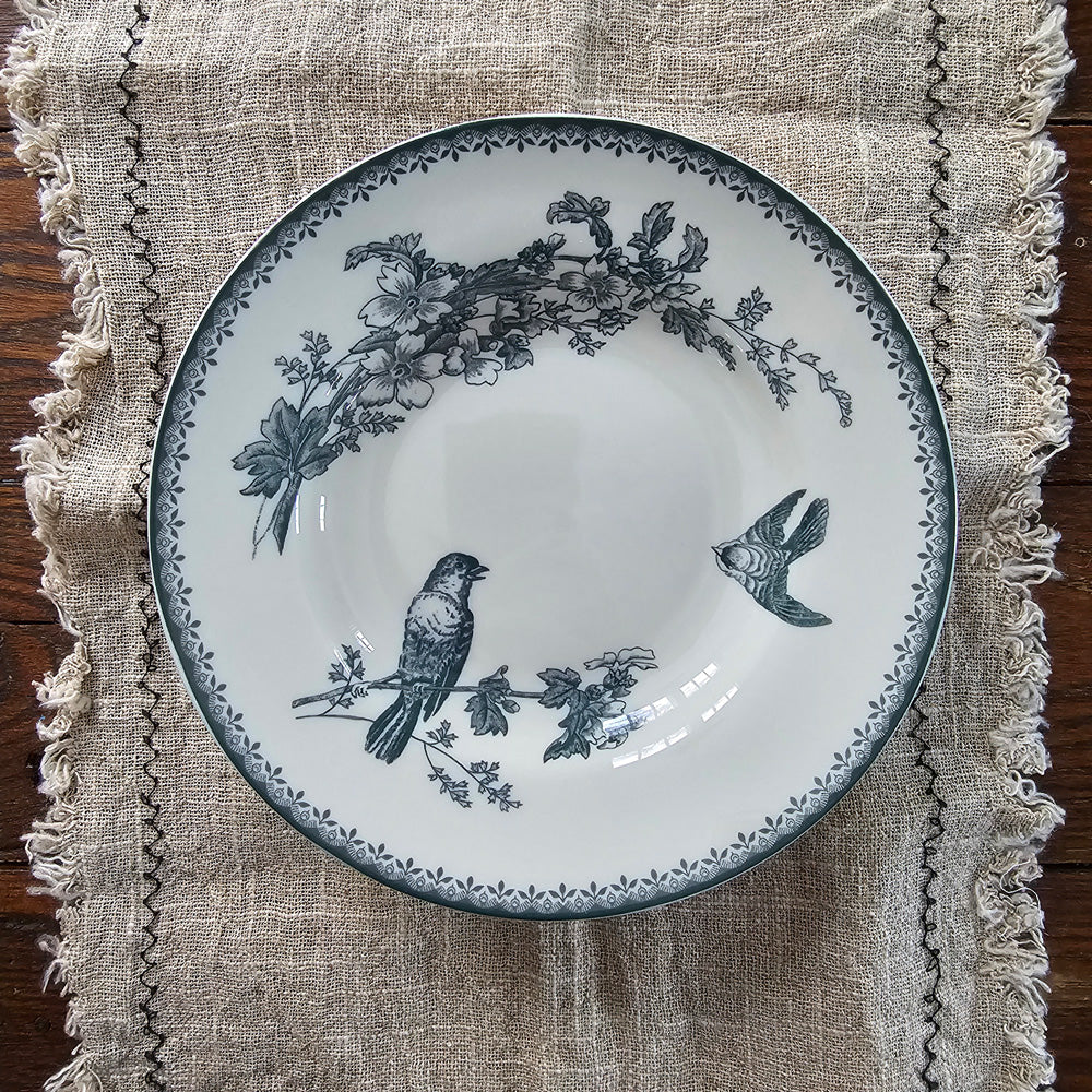 Inspired by antique transferware, our porcelain blue/green Bird Transferware Soup Bowl lends vintage cottage style to any shelf, tabletop or dinnerware collection. A vintage classic, transferware has adorned the shelves of American farmhouses for centuries. The delicate floral pattern in hunter green on an antique white background. Perfect for soups and salads. Food safe. Hand wash recommended. Includes one bowl. 8.88" Diam