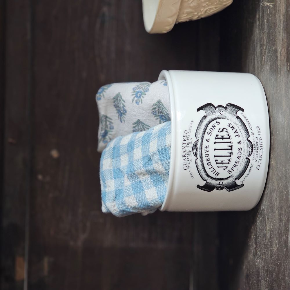 This handsome Jelly and Jam Crock is inspired by 19th century ironstone from potteries throughout England. This reproduction crock has a creamy white color with a decorative black old-timey logo. This beautiful accent crock adds old-world charm to any room. Use to store cooking utensils or display your favorite flowers.