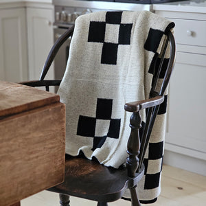 This Knit Reversible Cross Throw Blanket is made of a cozy wool blend, perfect for cuddling up on the couch. It features a unique reversible design with a beige and black cross geometric pattern that gives this throw handsome character with a vintage camp feel. Make this cozy throw part of your home decor for a timeless look and added comfort. 30% Wool, 70% Acrylic. Hand wash recommended. 50" x 60"