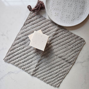 This super soft vintage style Knit Washcloth with Tassel adds a bit luxury to your bathing experience. Handmade of 100% Certified Organic Cotton, this knit washcloth, with its diagonal weave pattern, is designed for scrubbing without damaging the skin. Featuring a braided tassel that serves as a hook for drying while adding a decorative touch. The neutral, warm gray color complements any color scheme. 