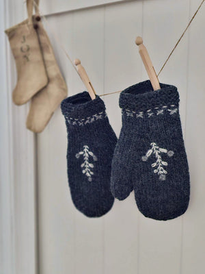 Crafted with intention, these hand-knit mittens marry understated Nordic style with everyday warmth. The charcoal foundation provides a versatile canvas for delicate white tree embroidery and cuff detailing that whispers rather than shouts. Lined with plush fleece, they transform ordinary moments—a morning stroll, a quick errand, or cradling your favorite beverage—into small rituals of comfort. 