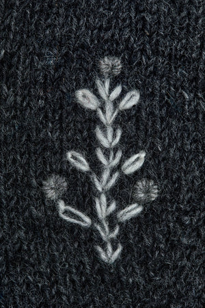 Crafted with intention, these hand-knit mittens marry understated Nordic style with everyday warmth. The charcoal foundation provides a versatile canvas for delicate white tree embroidery and cuff detailing that whispers rather than shouts. Lined with plush fleece, they transform ordinary moments—a morning stroll, a quick errand, or cradling your favorite beverage—into small rituals of comfort.