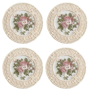 The Lace Embroidered Floral Coaster Set adds timeless elegance to coffee tables, vanities, and dining spaces. Designed with intricate lace detailing and a delicate floral embroidered center, this decorative coaster brings vintage-inspired charm to your home. The fabric construction helps absorb light condensation while providing a soft barrier between cups and surfaces. Ideal for everyday use or display, it combines romantic detailing with practical table protection. Set of four. 4.75" Diam