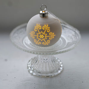 The Lighted Snowflake Ornament Set brings an enchanted winter touch to your home. Features a crisp, white un-glazed ceramic, lending a quiet elegance with an organic, minimalist feel. The snowflake design has a lace-like quality. Each has a flat bottom, so it can easily sit on a shelf or hang from a tree. 