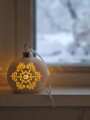 The Lighted Snowflake Ornament Set brings an enchanted winter touch to your home. Features a crisp, white un-glazed ceramic, lending a quiet elegance with an organic, minimalist feel. The snowflake design has a lace-like quality. Each has a flat bottom, so it can easily sit on a shelf or hang from a tree. 