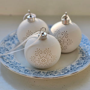 The Lighted Snowflake Ornament Set brings an enchanted winter touch to your home. Features a crisp, white un-glazed ceramic, lending a quiet elegance with an organic, minimalist feel. The snowflake design has a lace-like quality. Each has a flat bottom, so it can easily sit on a shelf or hang from a tree. 